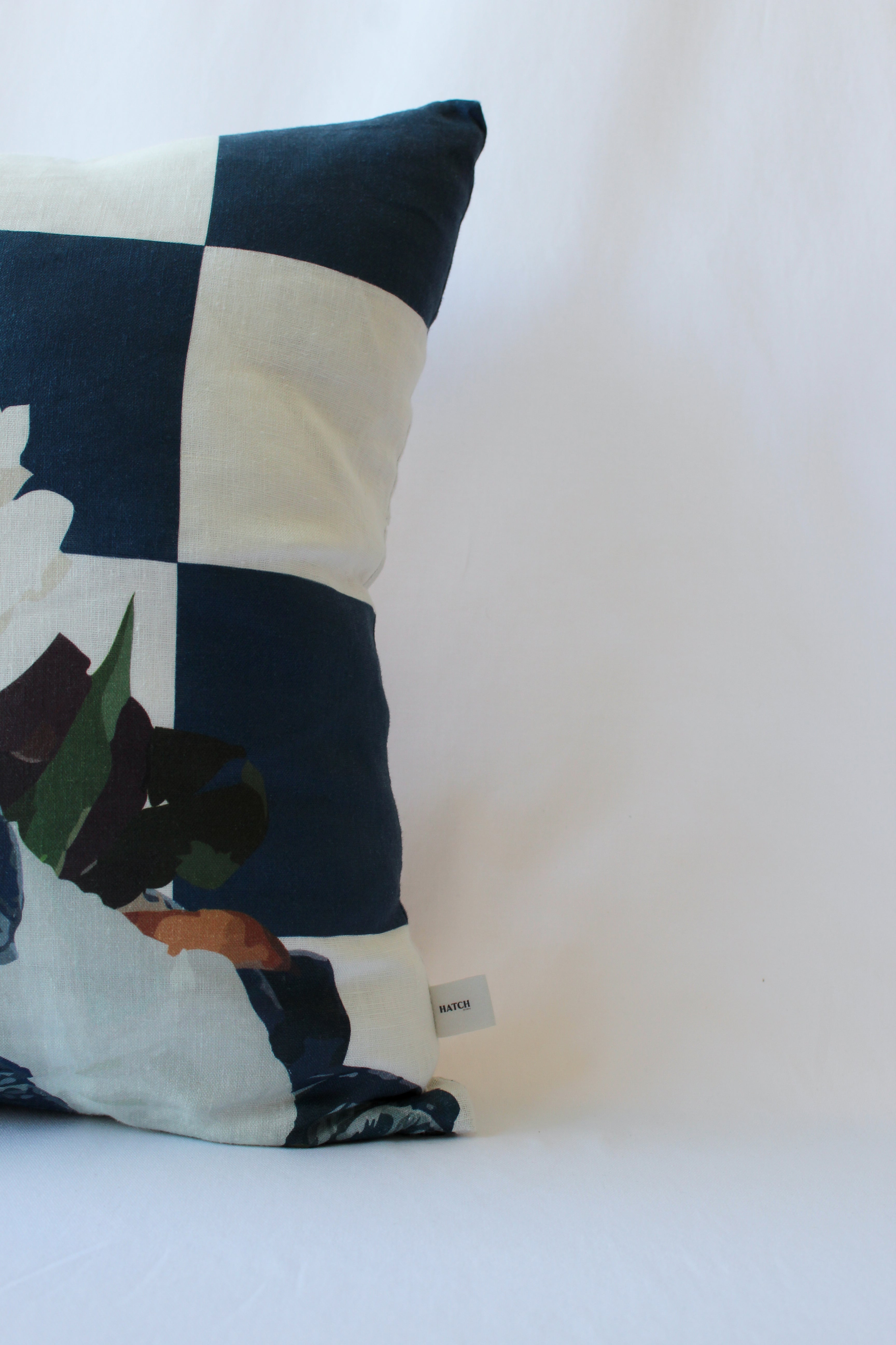 Check and floral designs on a luxury linen cushion designed in-house by our founder