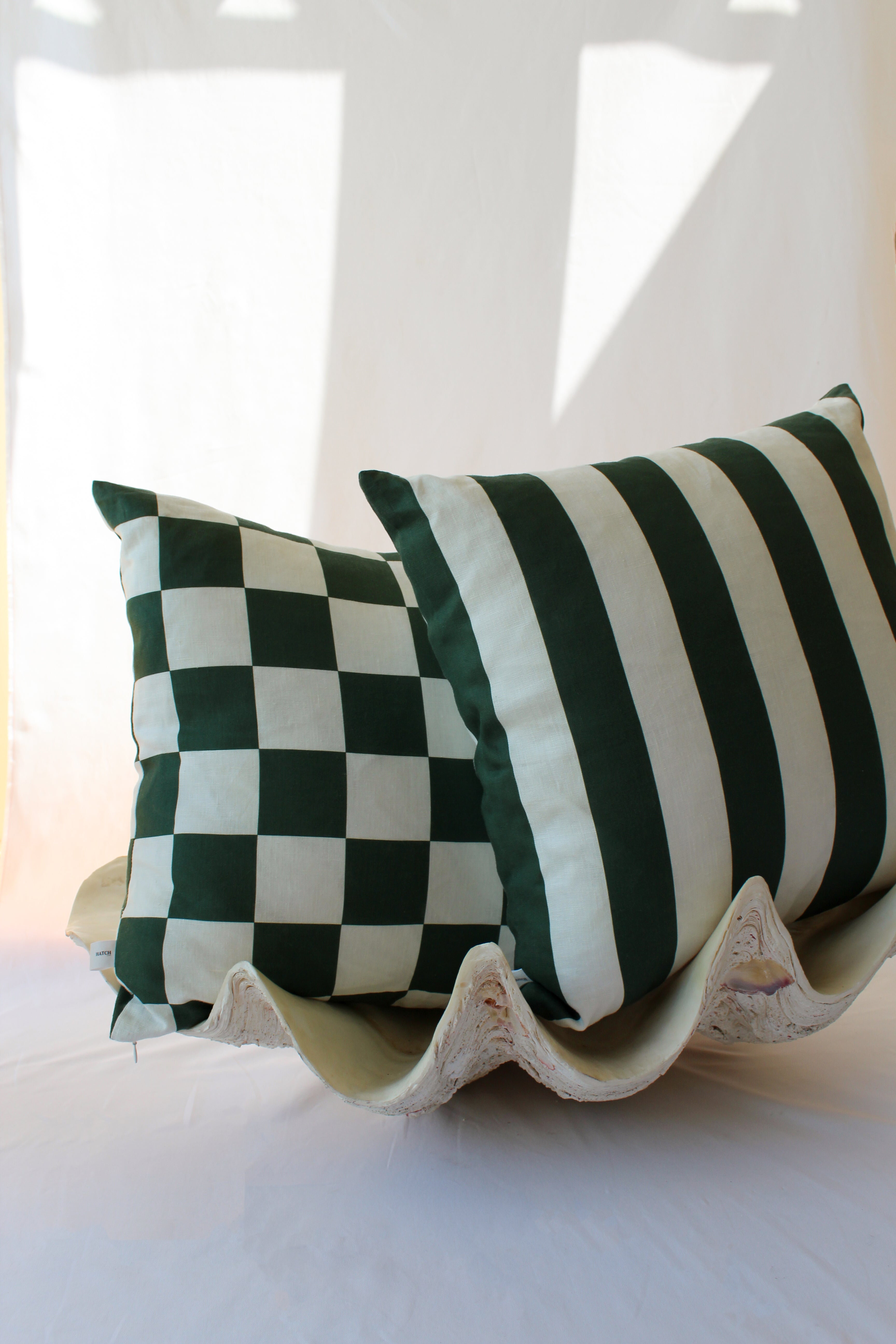 Dark green checkered and striped double sided cushions in a coastal aesthetic