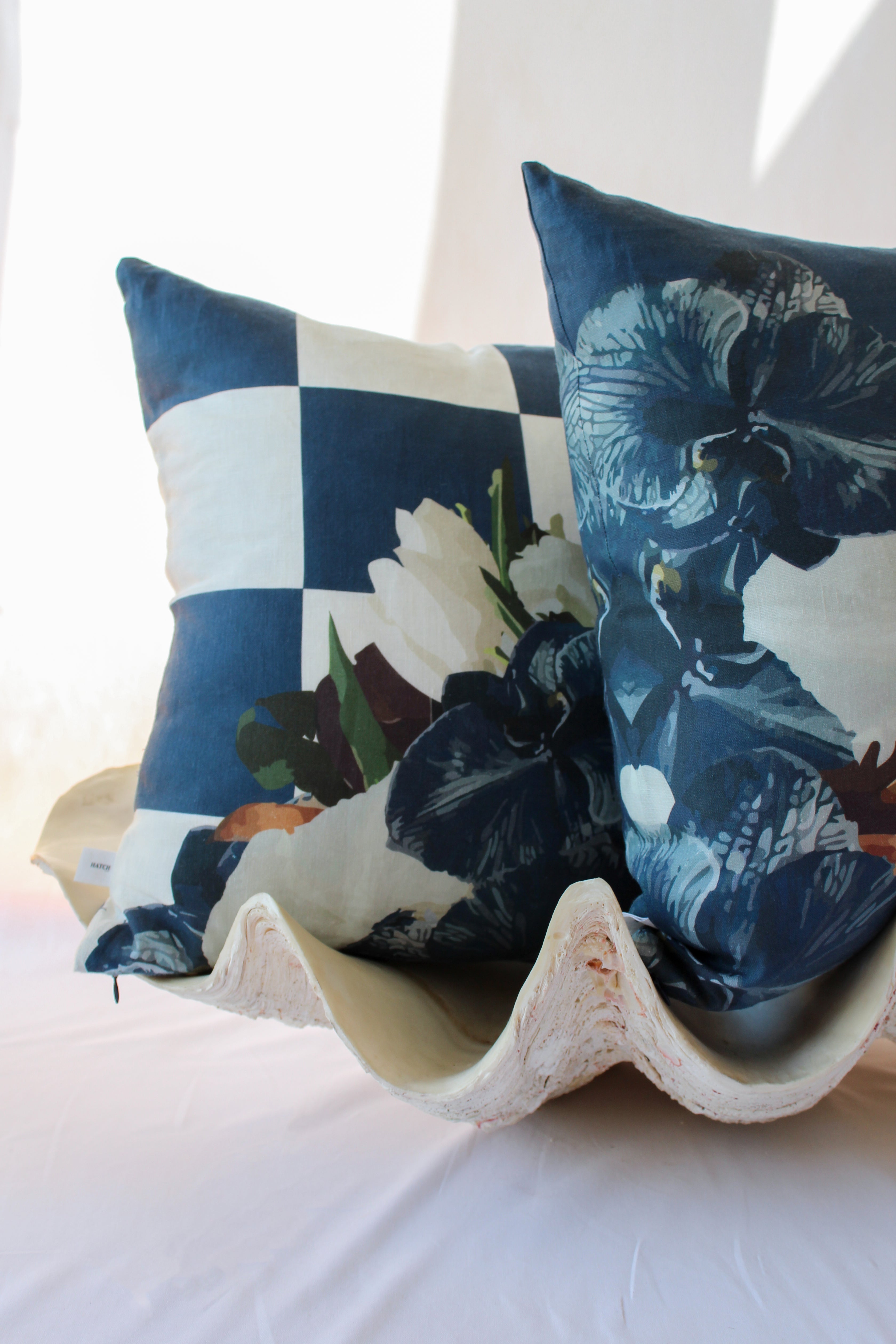 navy slate checkered and floral cushions styled in a clam for a coastal aesthetic