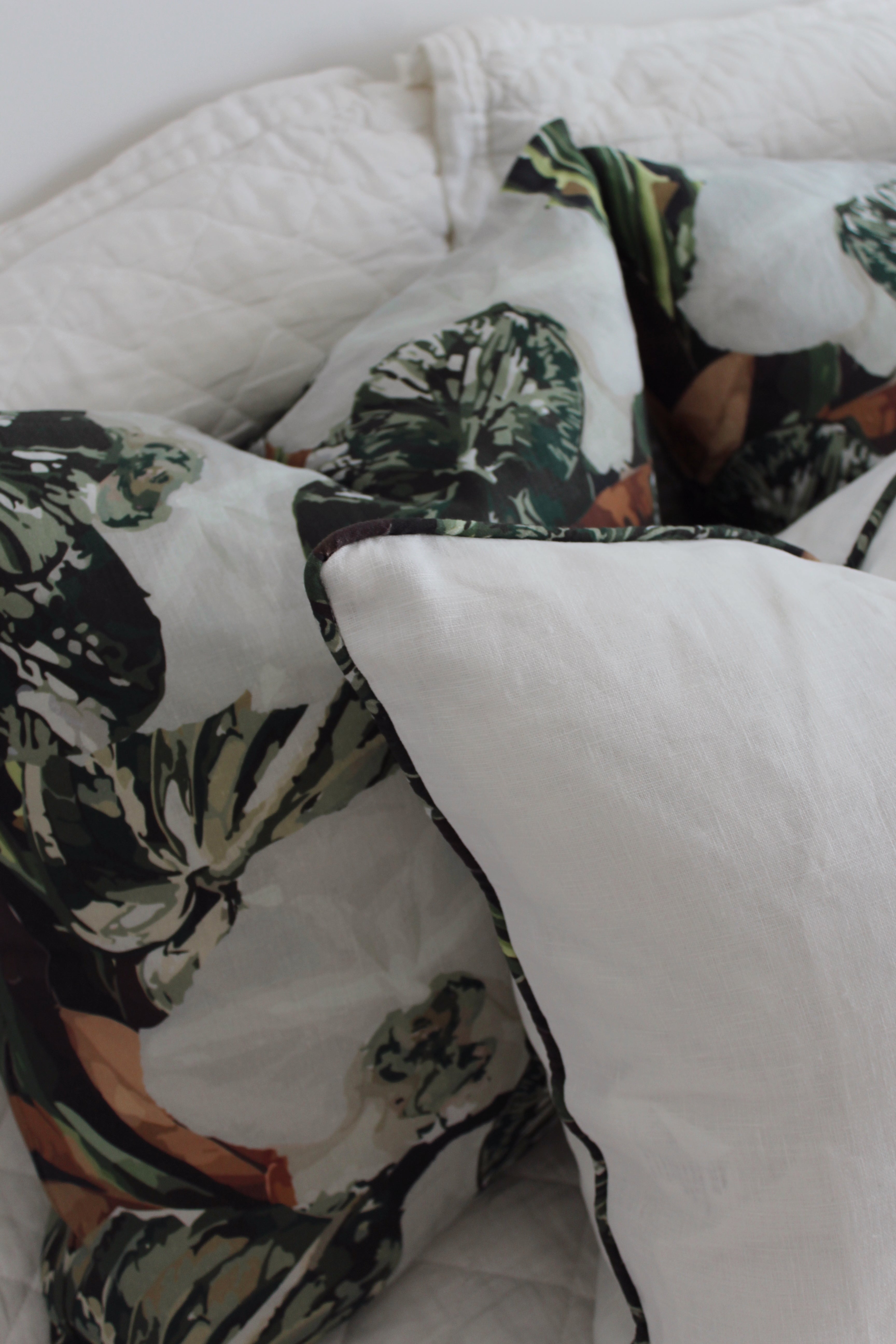 Close-up of eco-friendly pistachio-coloured cushion on a white linen bed