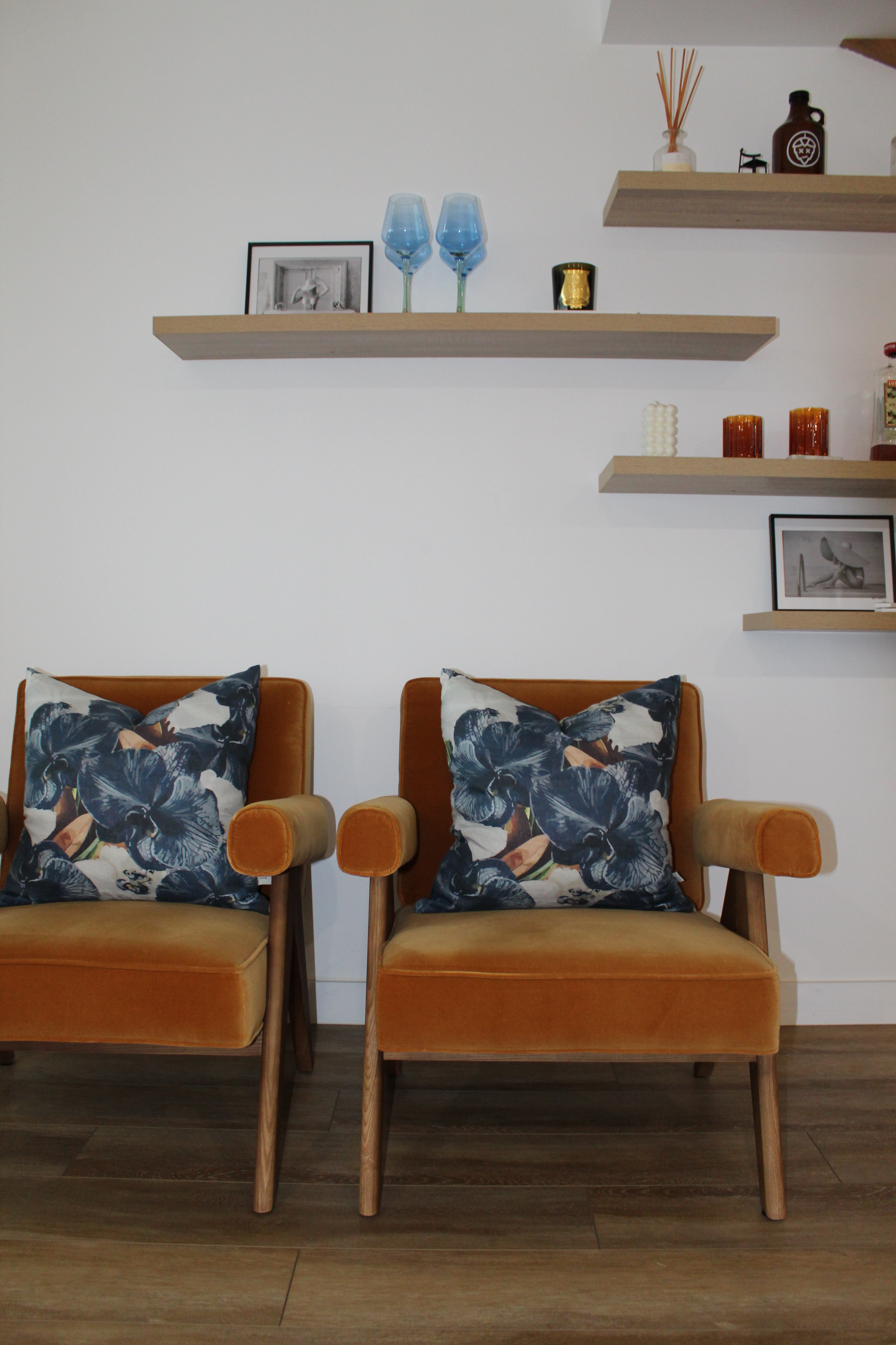 Navy slate floral cushion pair styled on orange modern armchairs